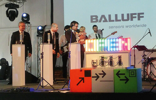 Przedstawiciele Balluff (od lewej): Michael Unger, Paweł Stefański oraz Florian Hermle dokonują symbolicznego otwarcia Centrum Inżynieryjno-Aplikacyjnego i wyświetla się napis „Open”